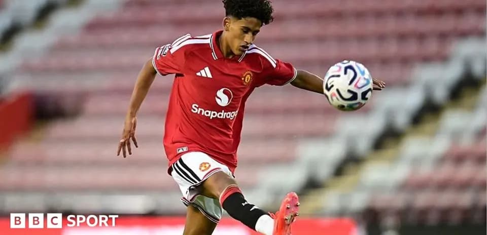 Player in Manchester United kit kicking a soccer ball