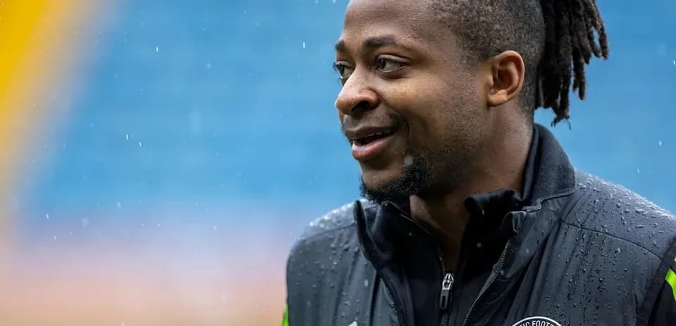 Player in rain-soaked training gear smiling outdoors
