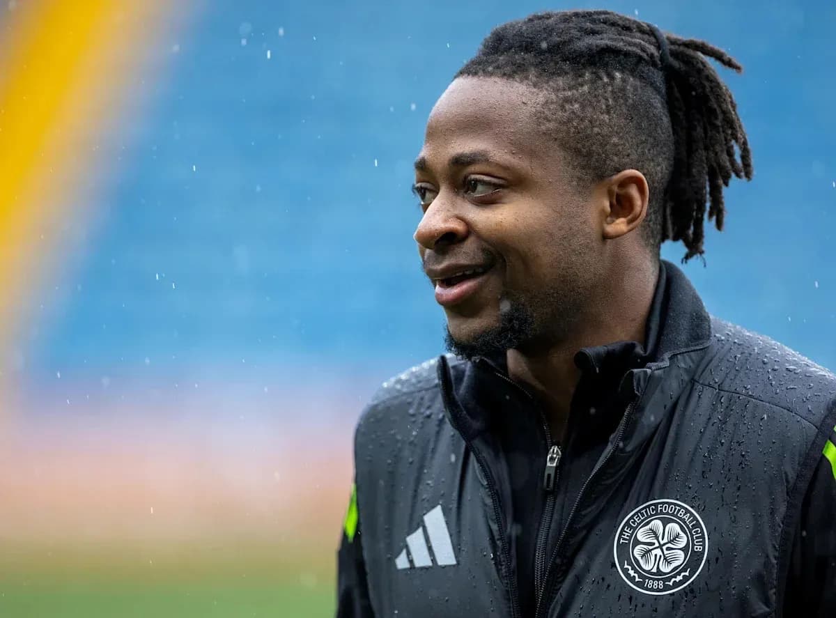 Player in rain-soaked training gear smiling outdoors