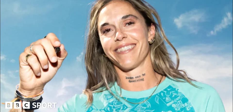 Athlete smiling while holding a pen outdoors