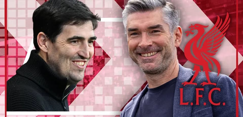Two coaches smiling against Liverpool FC backdrop