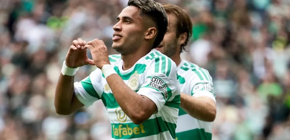 Player celebrating goal with heart gesture during match
