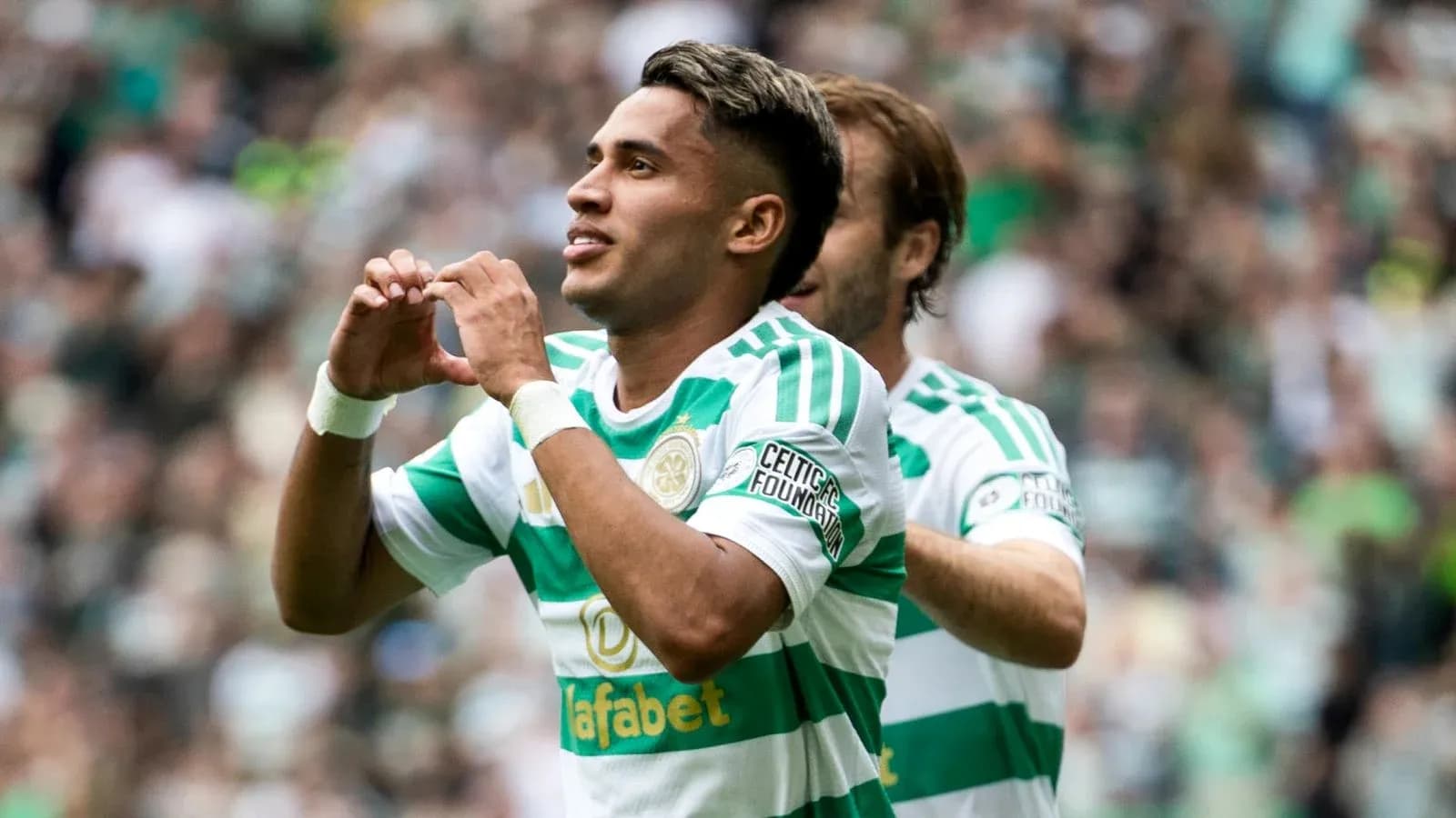 Player celebrating goal with heart gesture during match