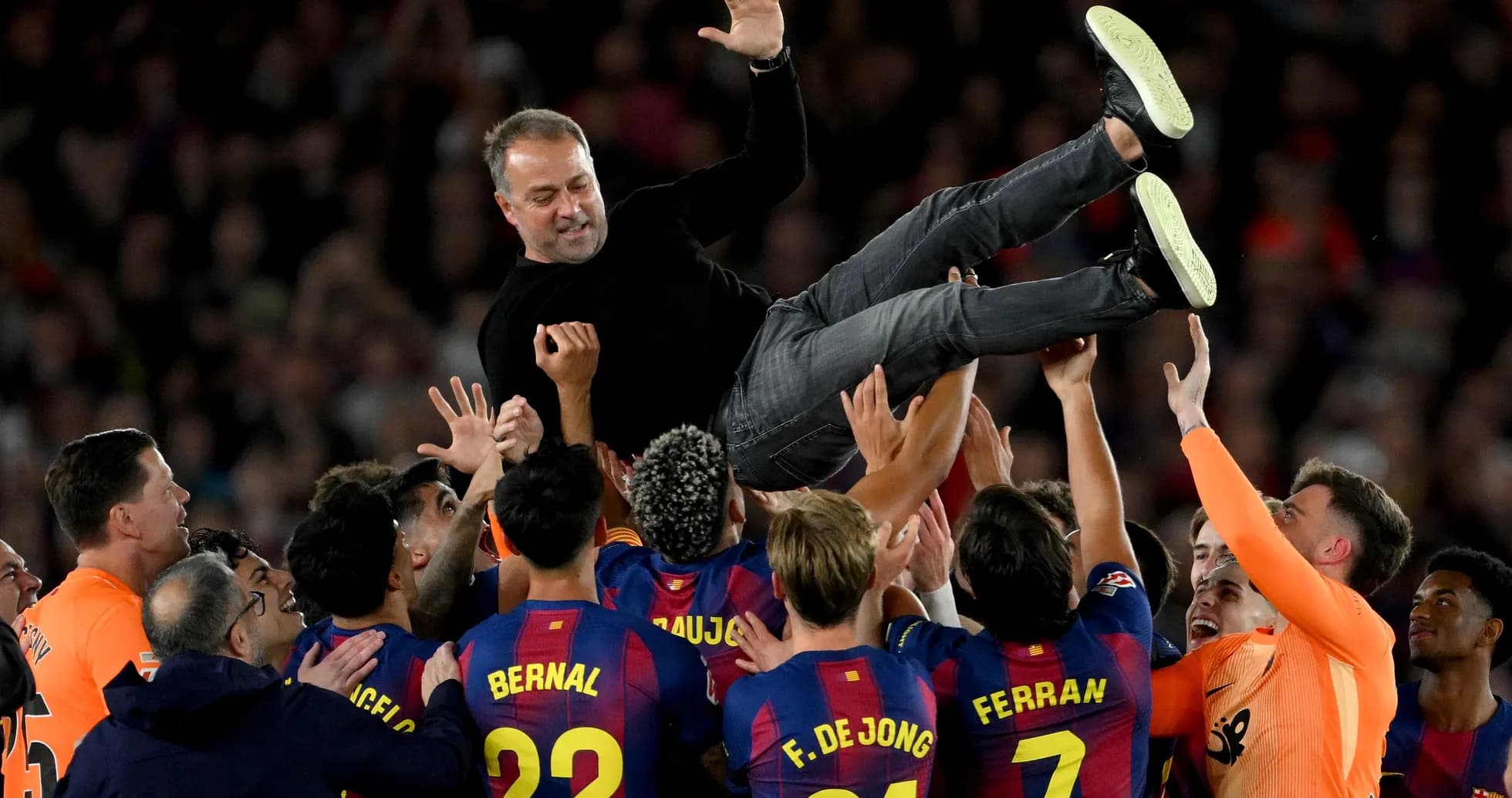Team celebrating by lifting the coach after victory
