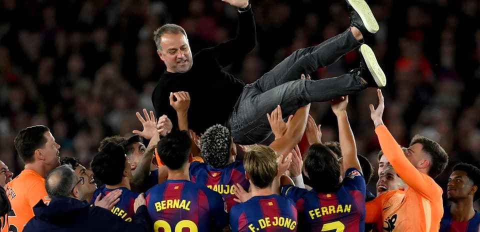 Team celebrating by lifting the coach after victory