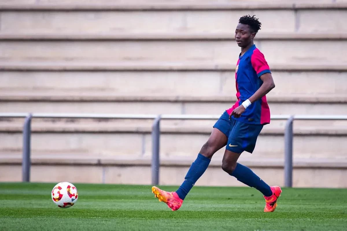 Player in FC Barcelona kit dribbling ball on pitch