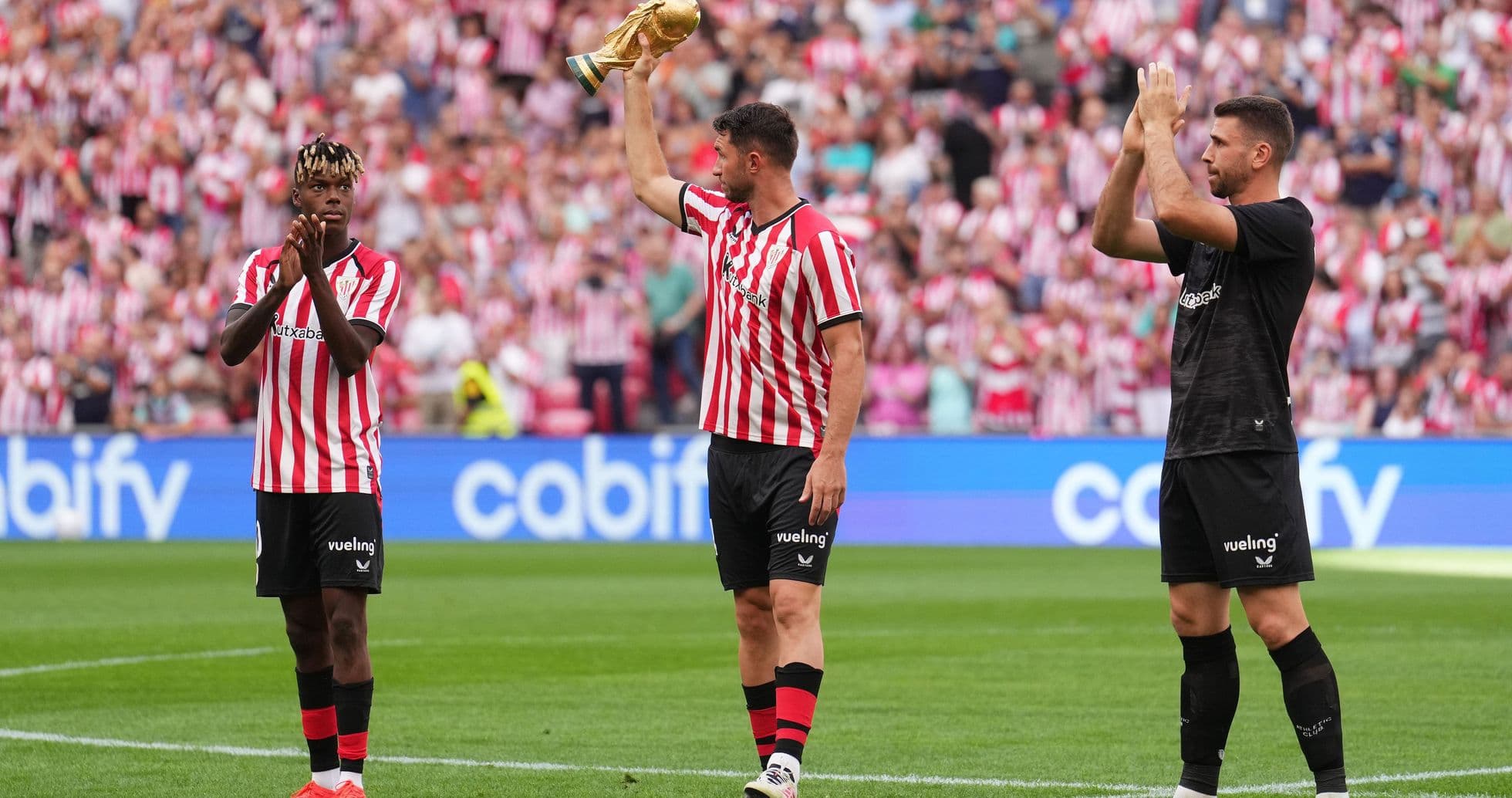 Players celebrating with a trophy in stadium