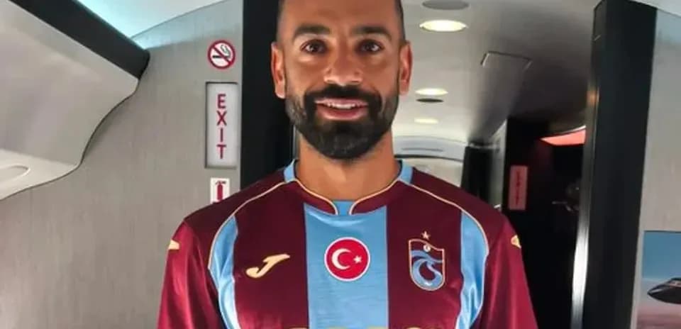 Player wearing Trabzonspor jersey inside airplane
