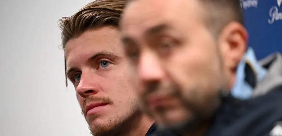 Two men at press conference, one in focus