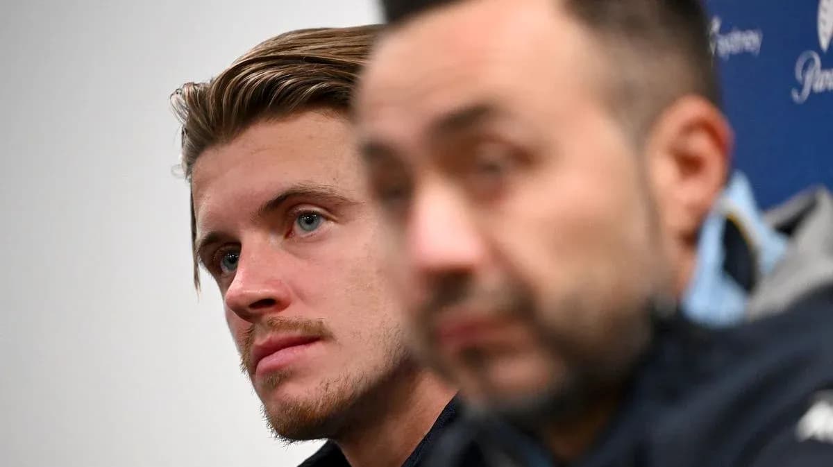 Two men at press conference, one in focus