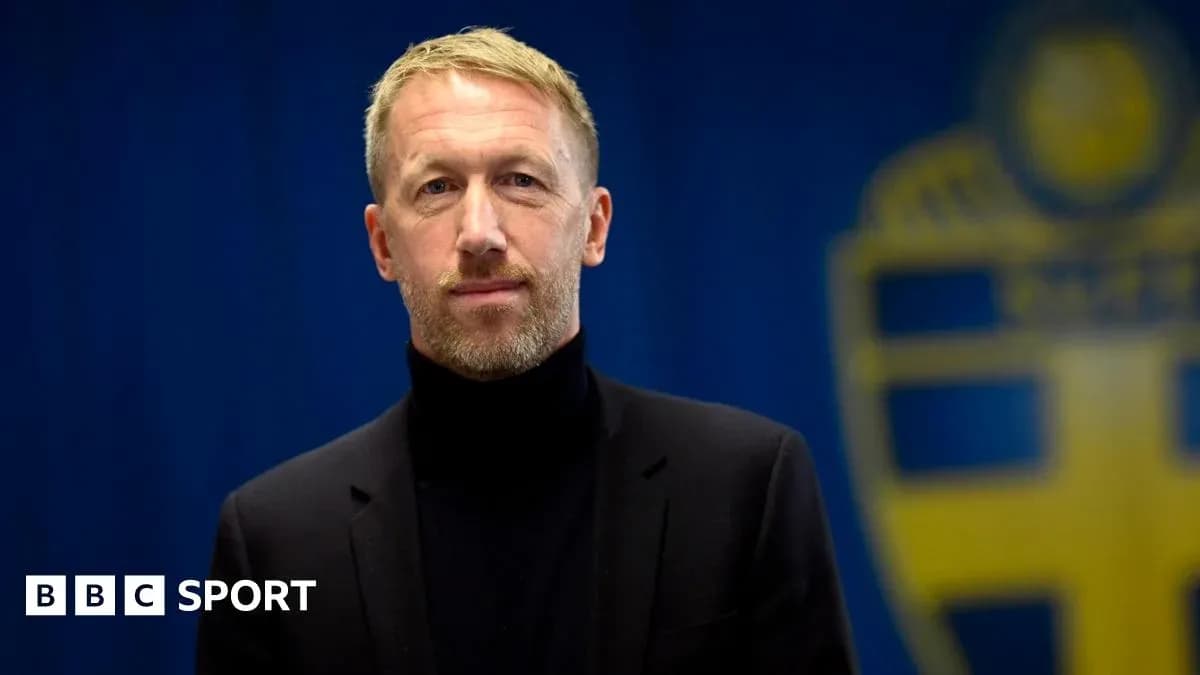 Man in black suit standing in front of backdrop