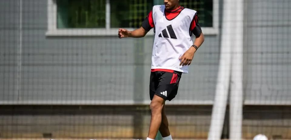 Player training on pitch with multiple soccer balls