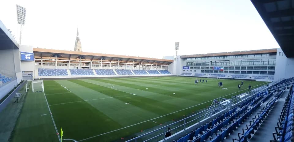 Football stadium with players warming up on pitch