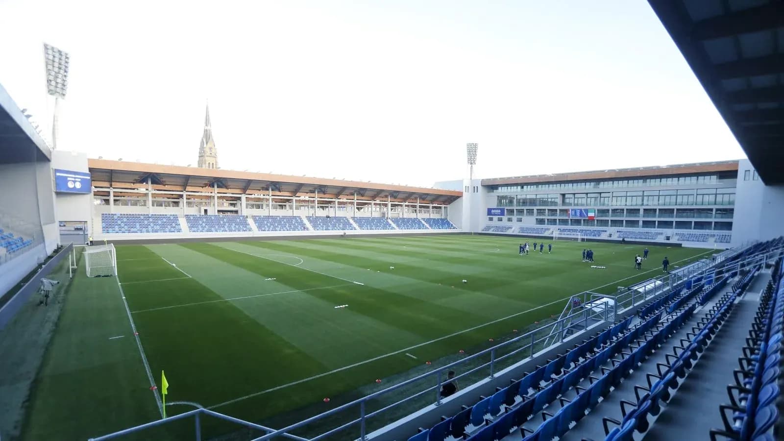 Football stadium with players warming up on pitch