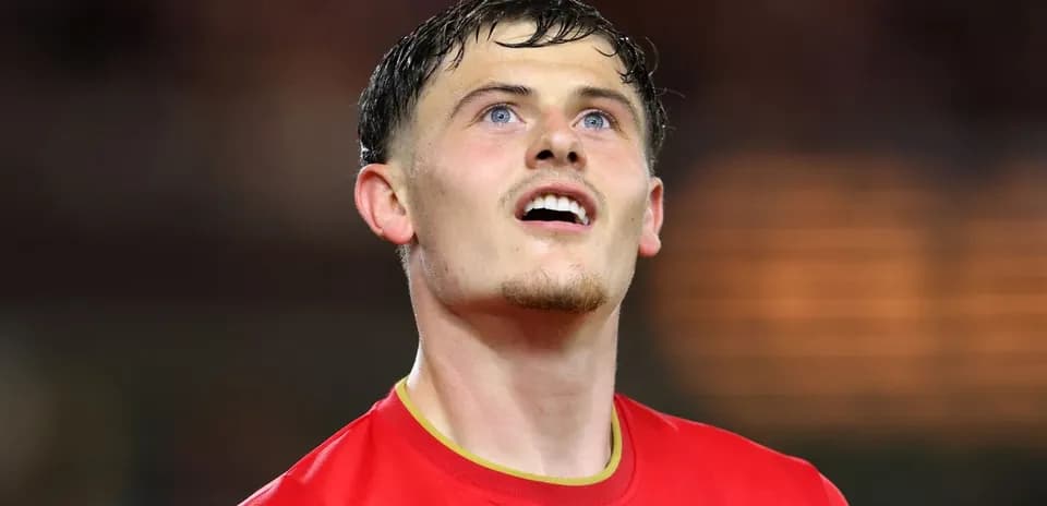 Player in red jersey looking upwards on field