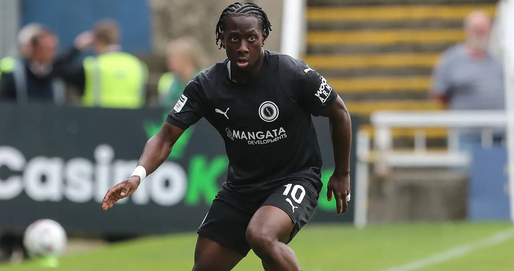 Player in black kit running on the pitch