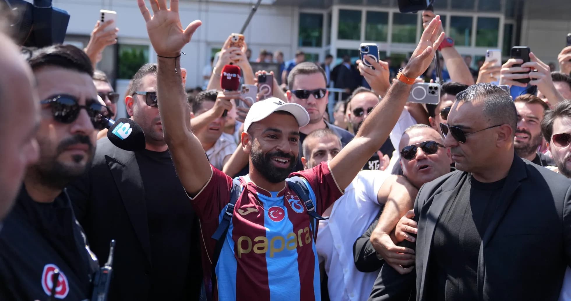Player greeting fans in crowded arrival scene
