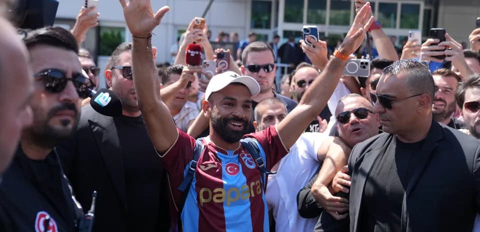 Player greeting fans in crowded arrival scene