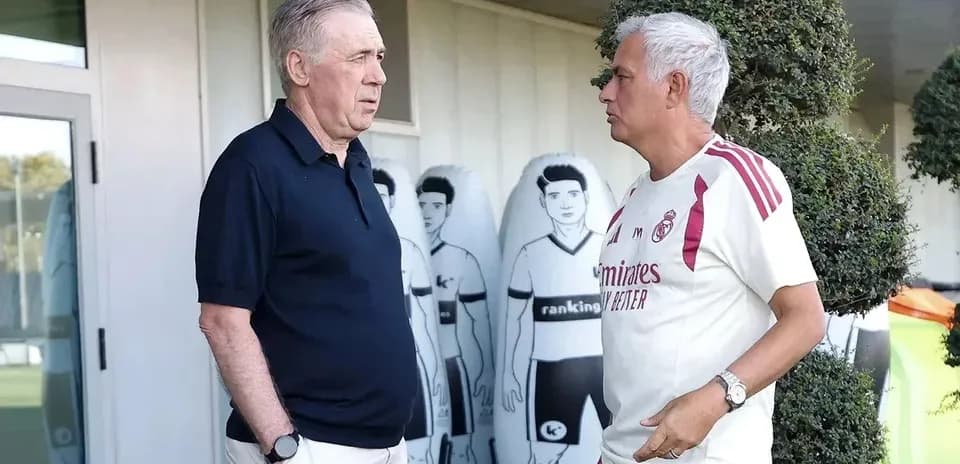 Two coaches conversing near training equipment