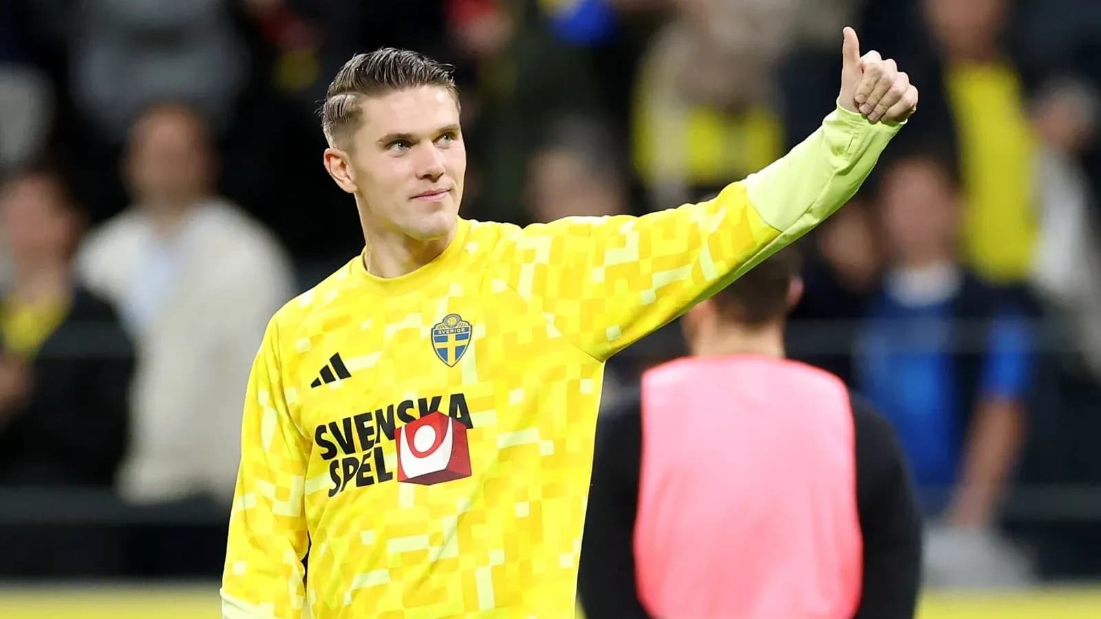 Goalkeeper in yellow jersey giving thumbs up