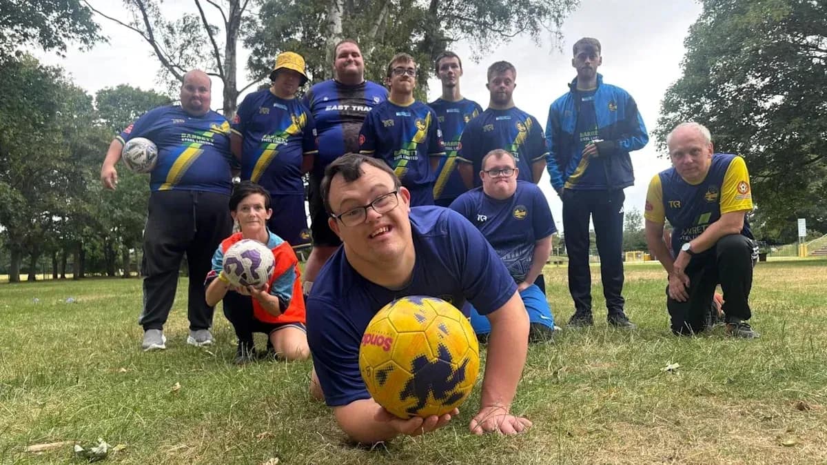 Group of players posing with soccer balls outdoors