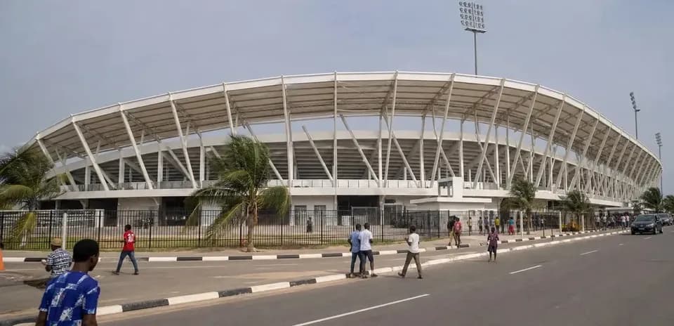 Exterior view of stadium with pedestrians and vehicles