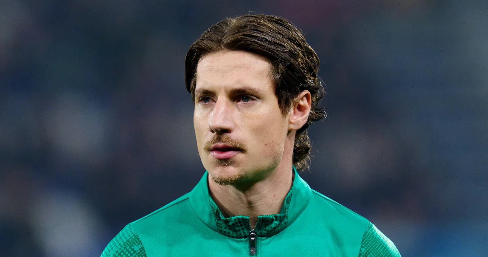 Goalkeeper in green kit during pre-match warm-up