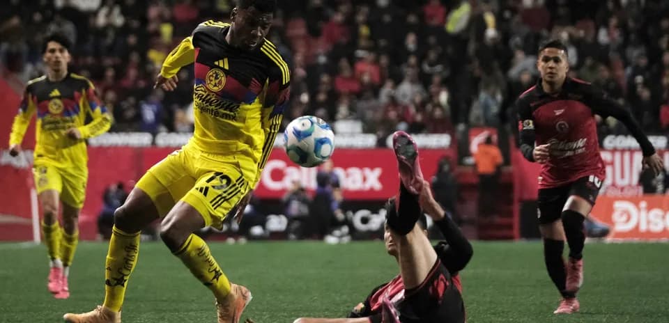 Club America player evading tackle during match