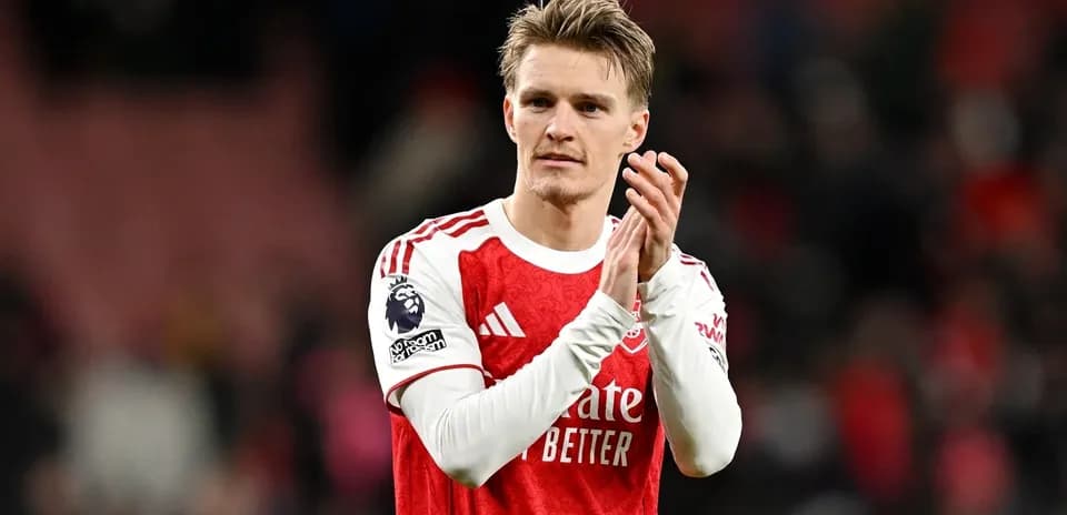 Player applauding fans after match wearing Arsenal kit