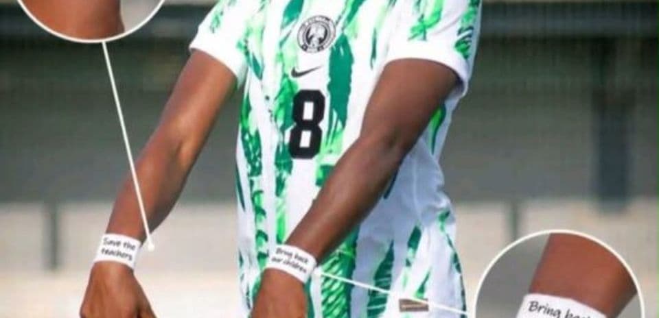 Football player displaying solidarity wristbands during match