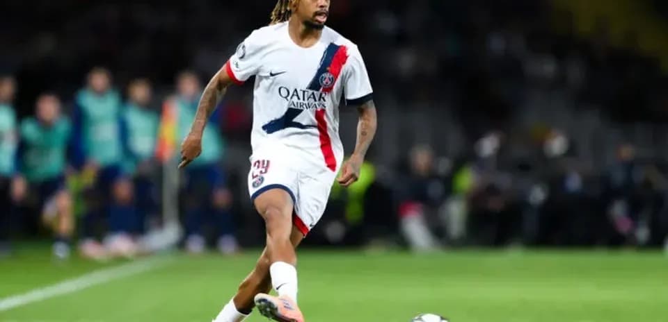Player in PSG kit dribbling the ball during match