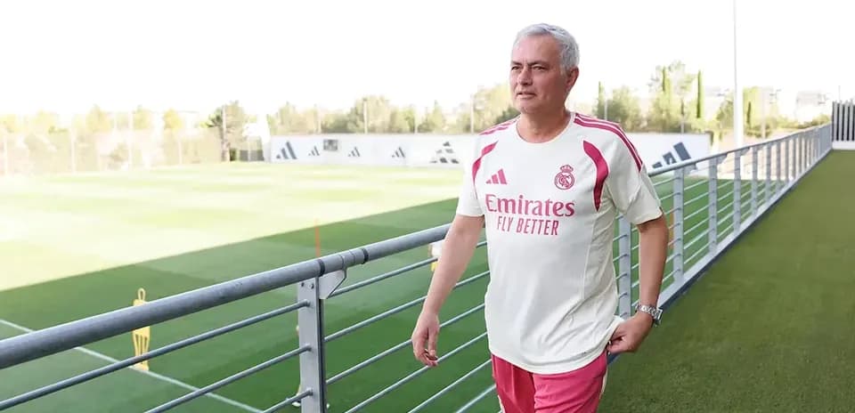 Coach walking on training pitch at facility