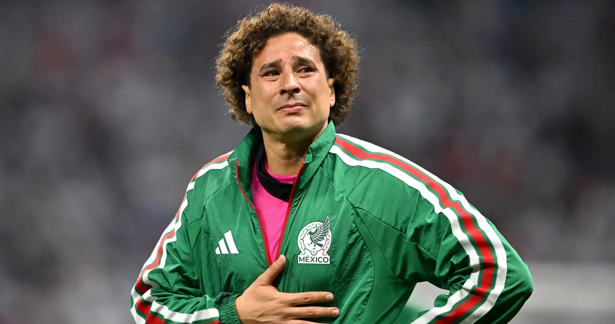 Goalkeeper wearing green jacket, hand on chest