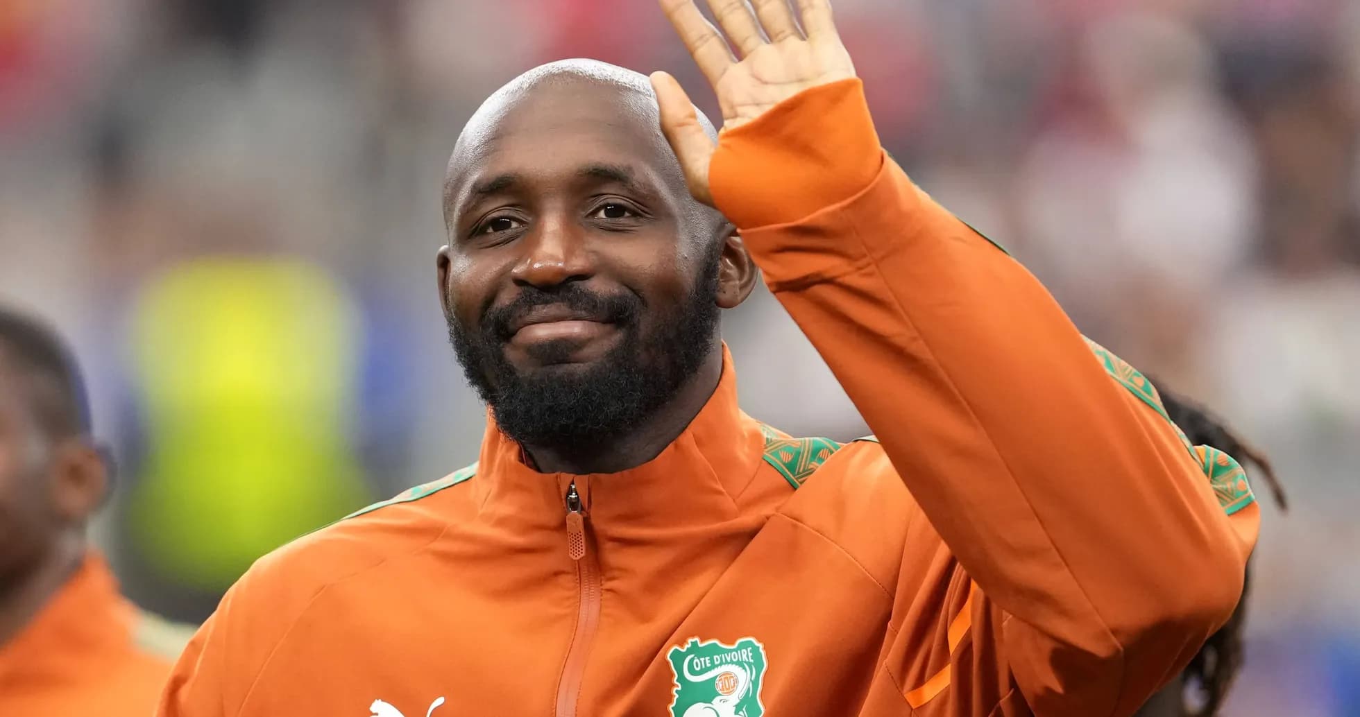 Player waving while wearing Ivorian national team jacket