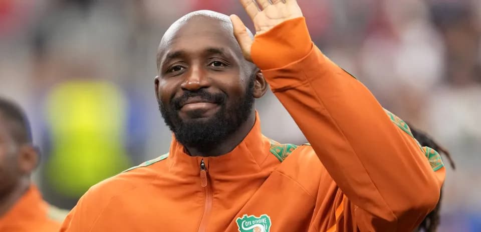 Player waving while wearing Ivorian national team jacket