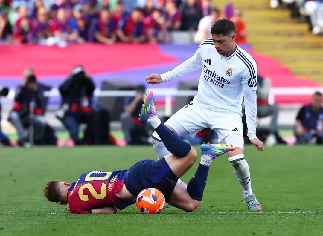 Player tackles opponent during Barcelona vs Real Madrid