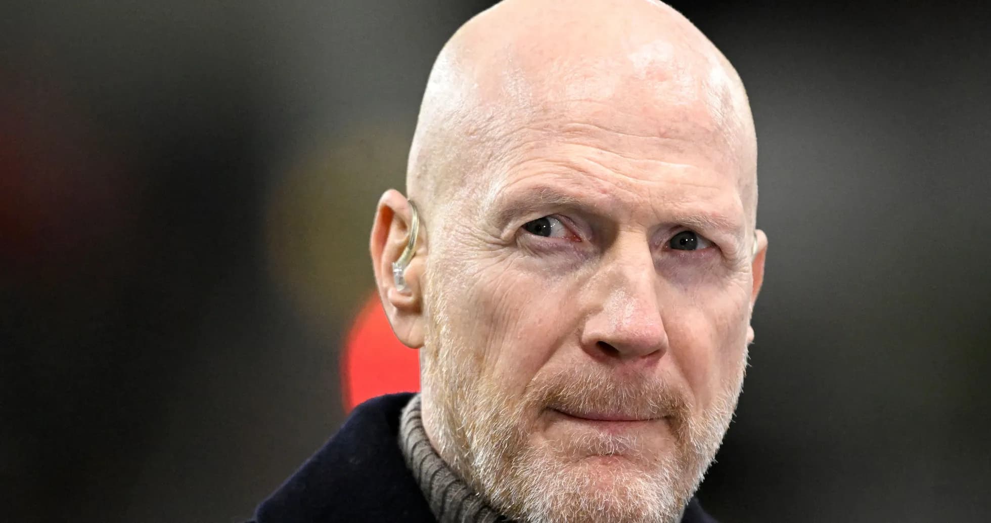 Bald man with a beard wearing an earpiece