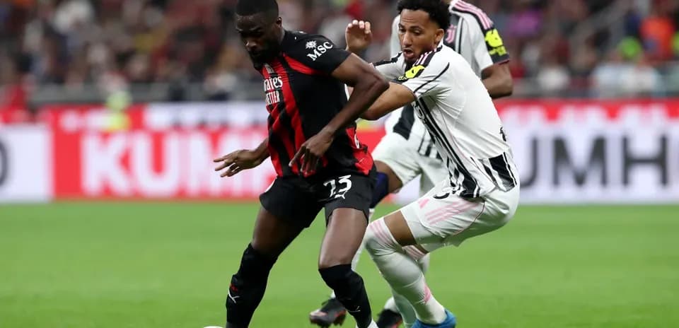 Players from Juventus and AC Milan battling for the ball