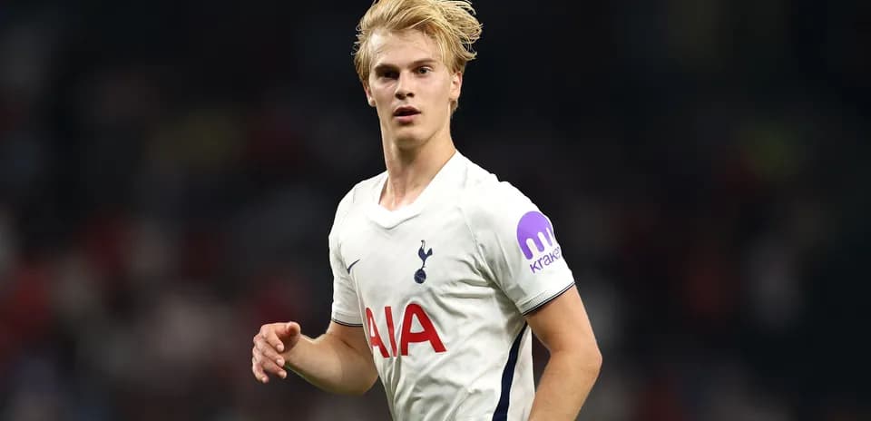 Player in Tottenham jersey running on the pitch