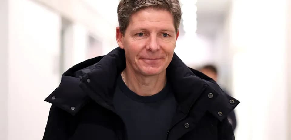 Man in black coat walking in hallway