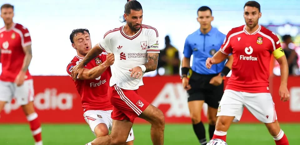 Player in white dribbling past opponent in red jersey