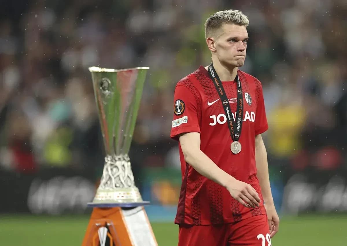 Player walking past UEFA trophy after match