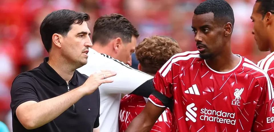 Coach discussing strategy with Liverpool player on sideline