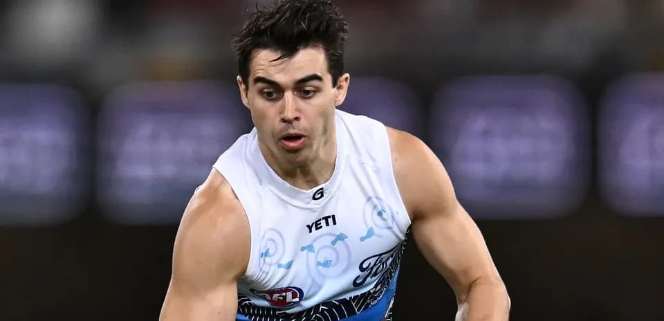 Player running with the ball during AFL match