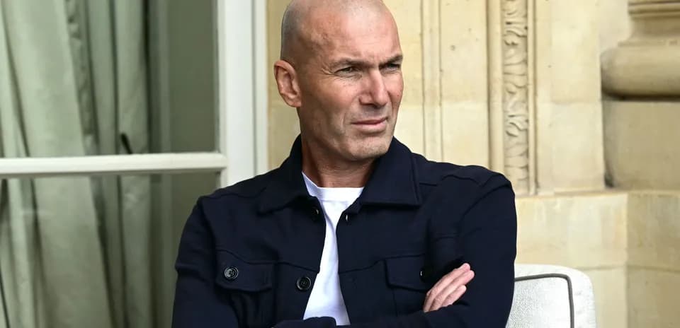 Man sitting with arms crossed, looking thoughtfully