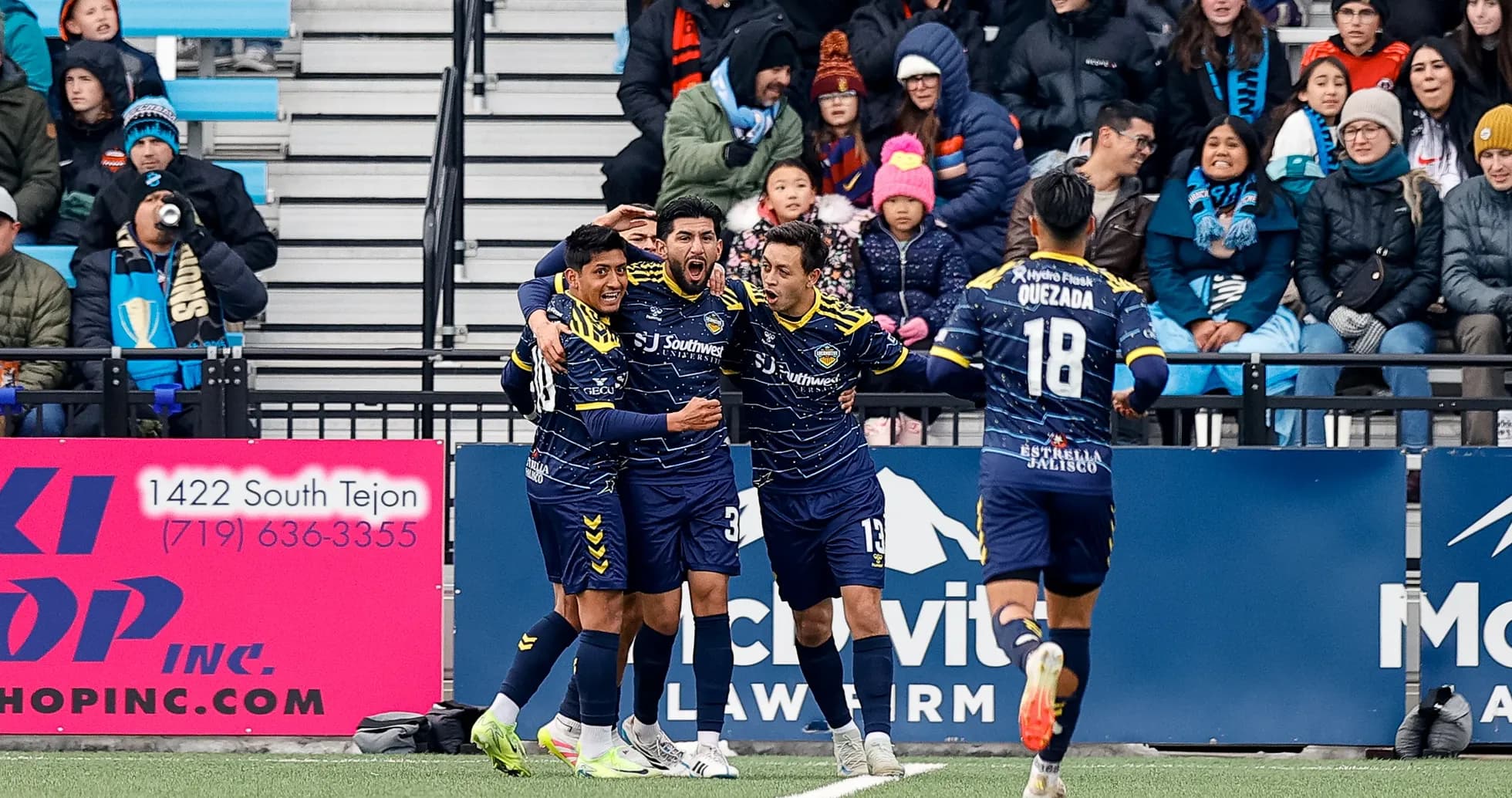 Players celebrating a goal during Colorado Springs match