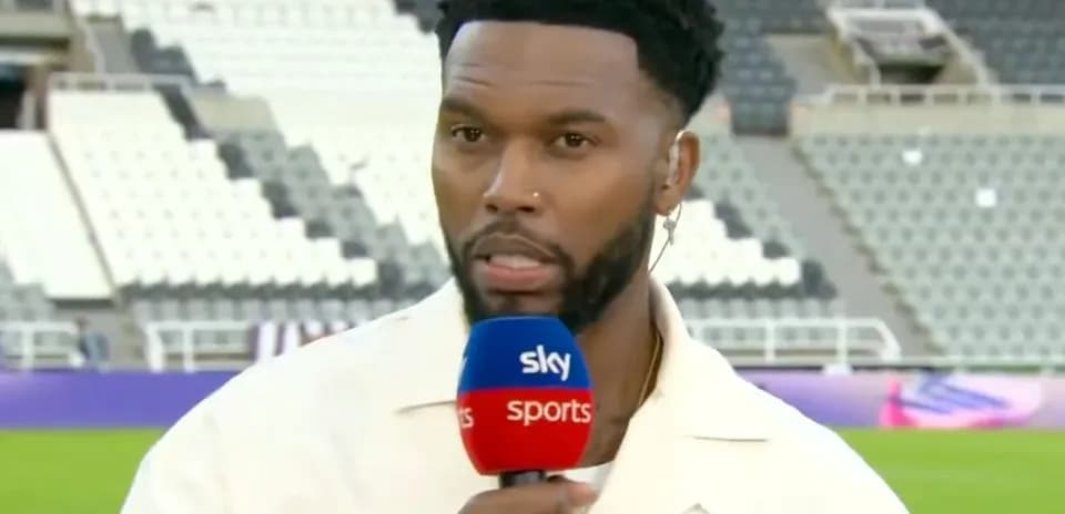 Sports presenter speaking into microphone on pitch