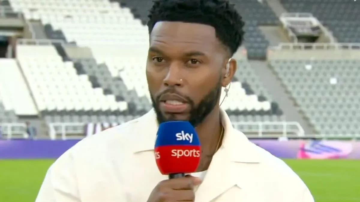 Sports presenter speaking into microphone on pitch
