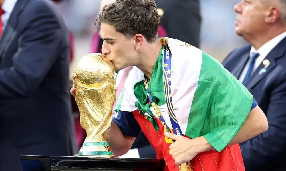 Player kissing World Cup trophy wearing national flag