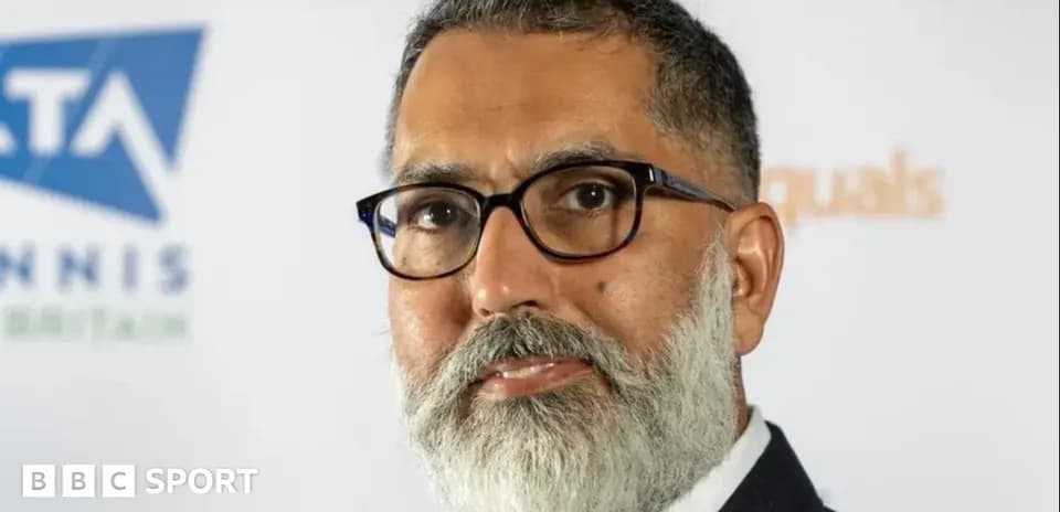 Man with glasses and beard at press event